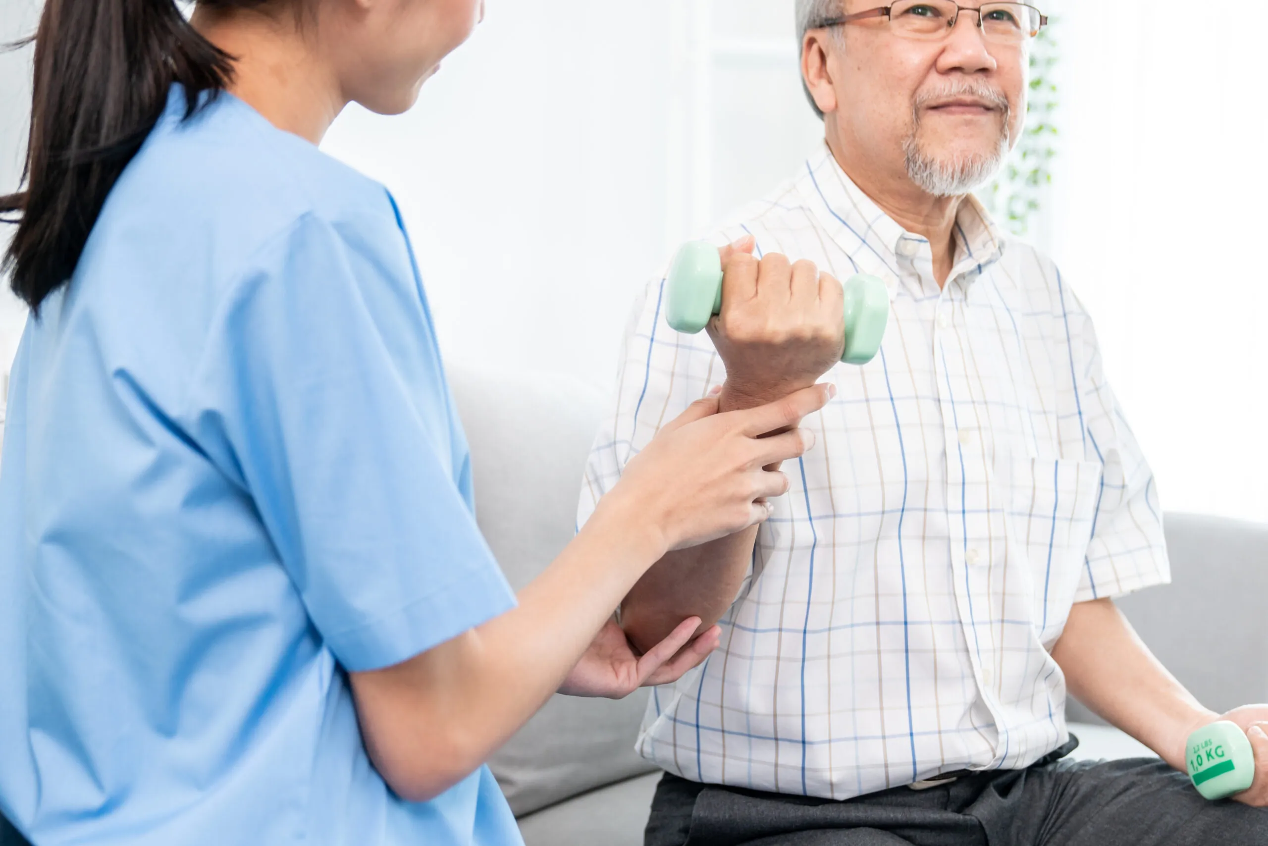 Contented senior patient doing physical therapy with the help of his caregiver. Contented senior patient doing physical therapy with the help of his caregiver. Senior physical therapy, physiotherapy treatment, nursing home for the elderly